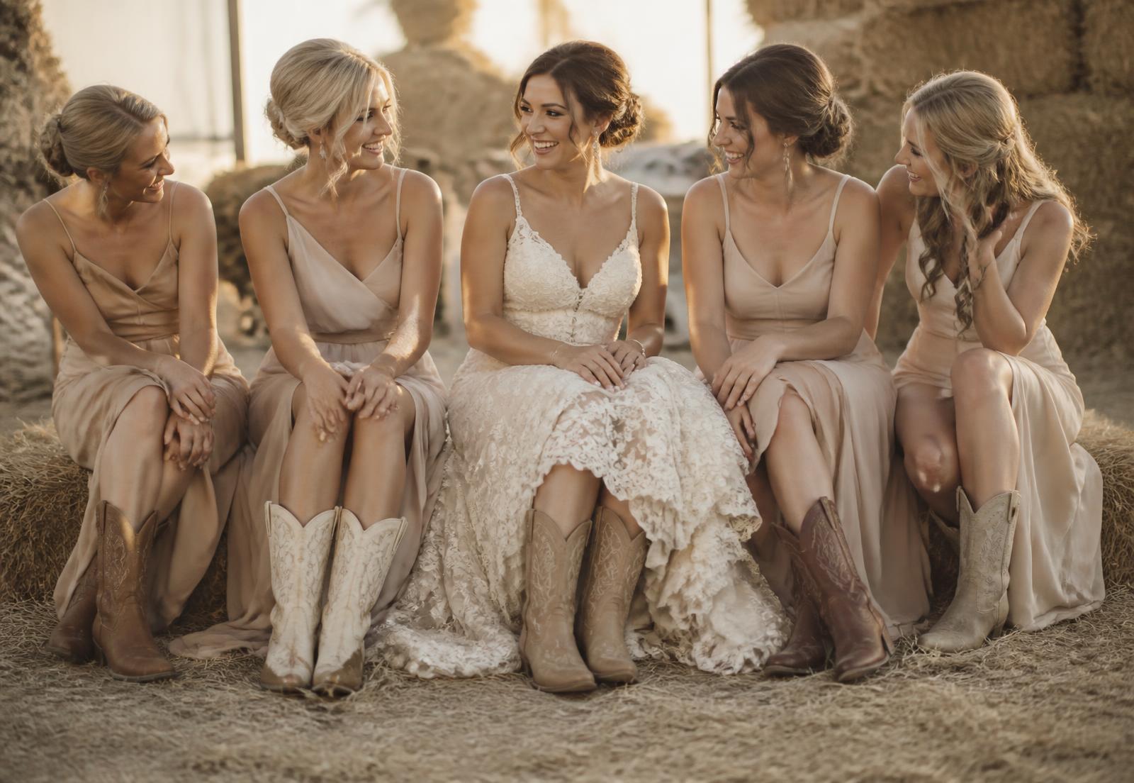 A bride and her bridesmaids seated together, all wearing western boots